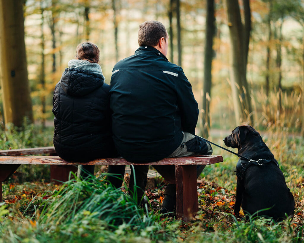 Par på bænk med hund